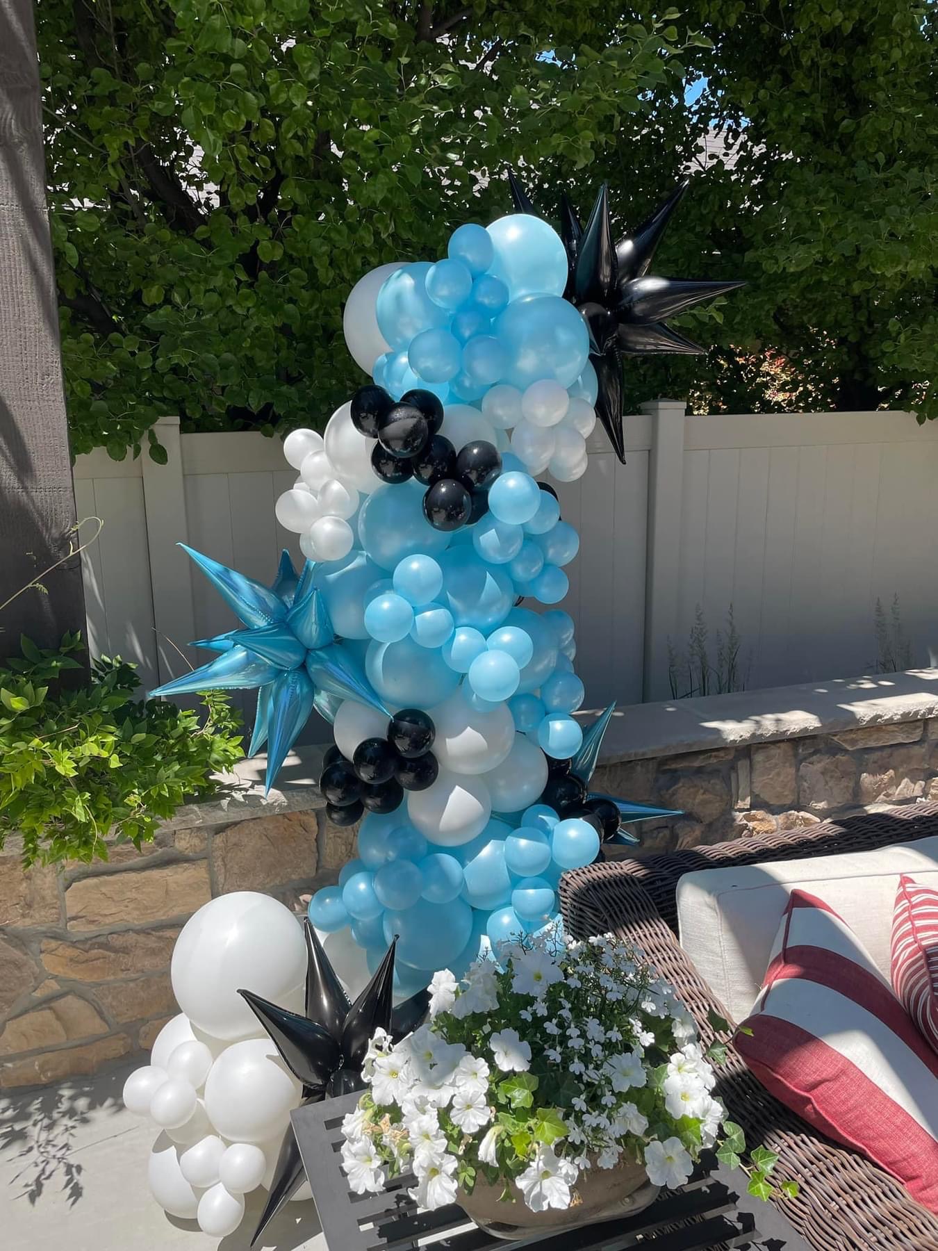 A sweet blue‑and‑white standing garland for an outdoor baby shower. Even balloons love a little shade.