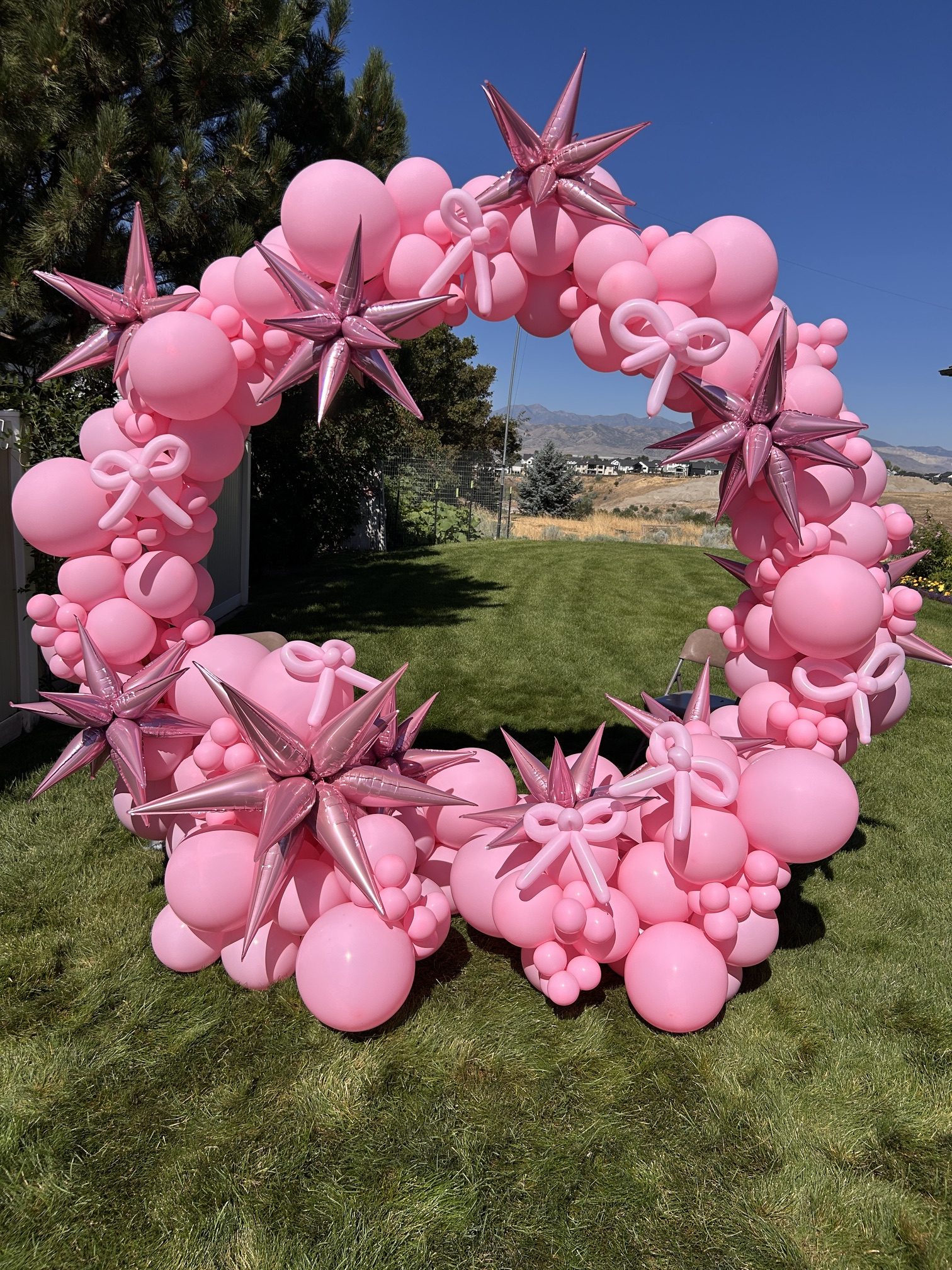 A full pink hoop with handcrafted balloon bows — perfect for adding height, color, and charm to any event.